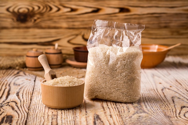 White rice in packing and bowl on a wooden background Healthy dietary cereals concept