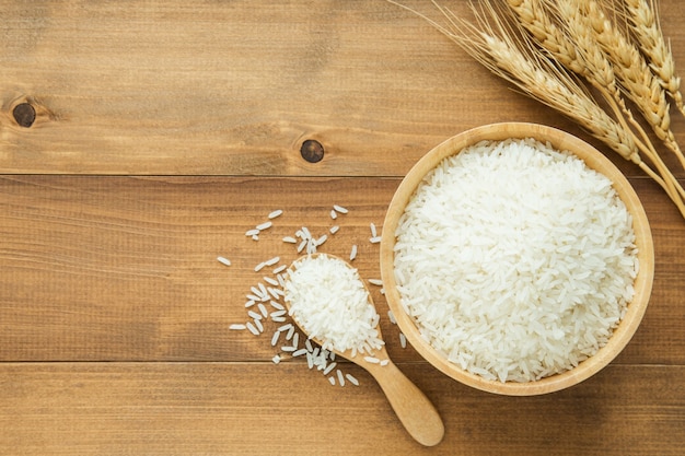 white rice (thai jasmine rice) in wooden bowl on wood background with copy space