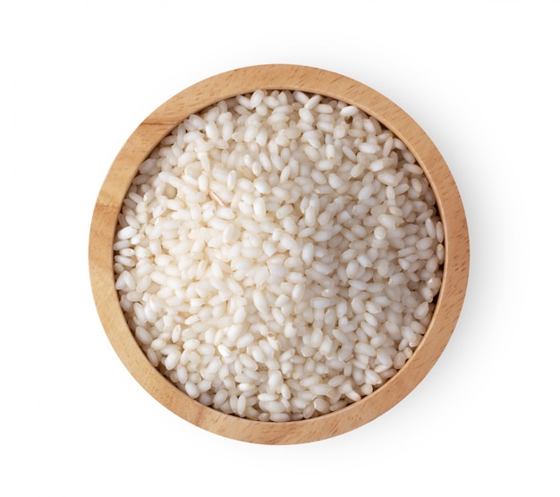 White rice in wood bowl on white table. 