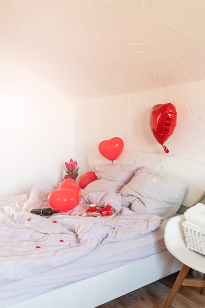 White romantic Valentine's Day bedroom with red hearts baloons