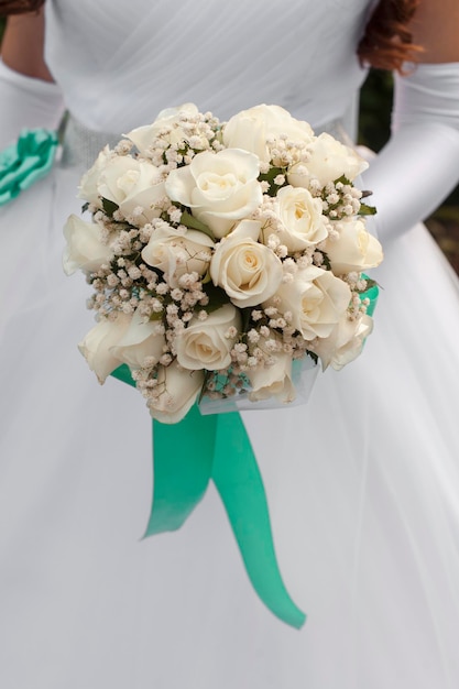 花嫁の手の中の白いバラのブーケ