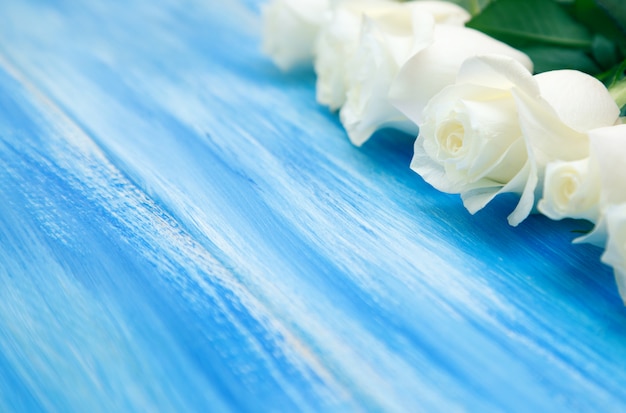 White Rose. A bouquet of delicate roses on a wooden blue background