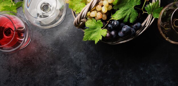 Photo white rose and red wine glasses and grape