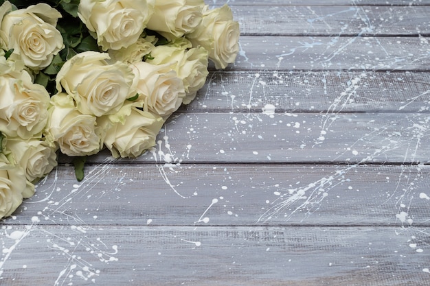 White roses on a gray wooden background. Copy space.