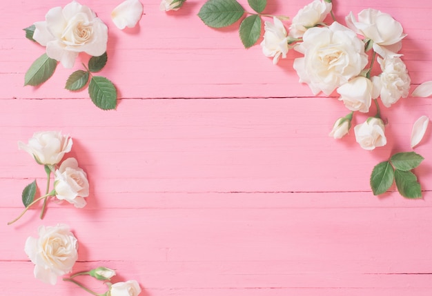 Белые розы на розовом деревянном фоне