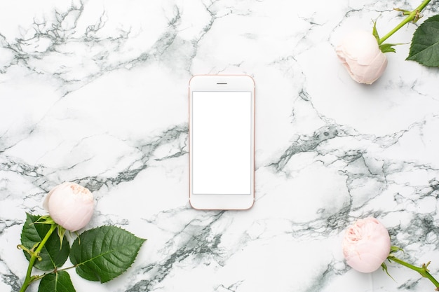 Copyspaceと白と黒の大理石の背景に携帯電話と白いバラ