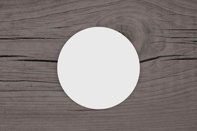 Foto mockup di adesivo rotondo bianco su fondo di legno grigio