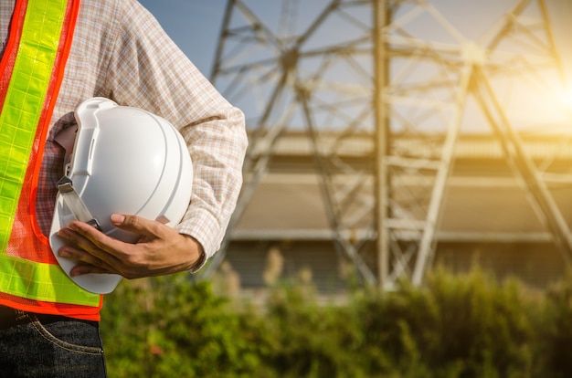 Il casco di sicurezza bianco è nelle mani di un elettricista.