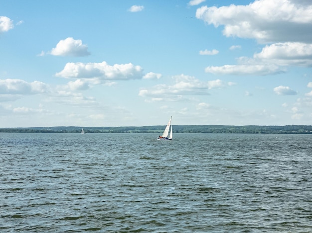 Photo white sailboat on the lake daytime landscape