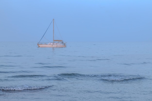 ブルーアワーの海の白いヨット落ち着きと静けさ