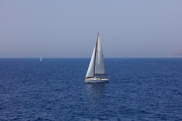 White sailing boat floating in sea