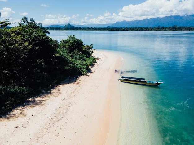 white sand beach by boat