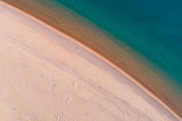 White Sand Beach and Calm Turquoise Sea. Aerial Vertical Top-Down View