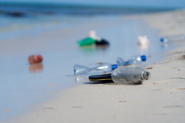 Белый песчаный пляж с пластиковым мусором, концепция загрязнения и воздействия на окружающую среду