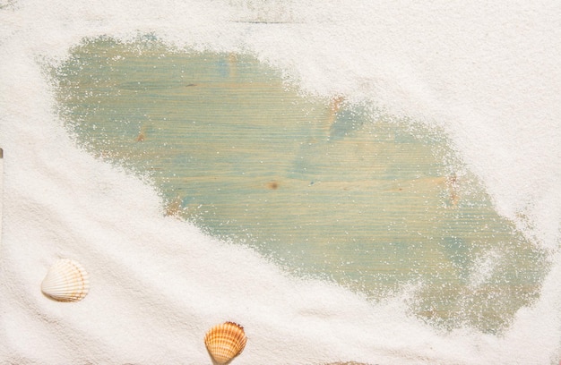 White sand and and shells on planked wood Summer background with copy space and frame for text Top view