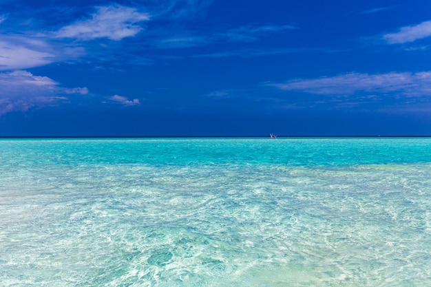 White sandy beach in Maldives with amazing blue lagoon and blue sky