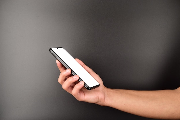 White screen smartphone in hand on dark background