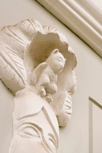 White sculpture of a small animal on the wall