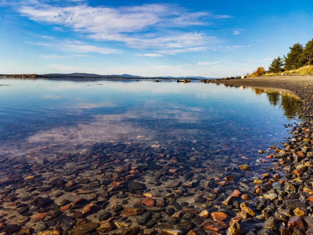 Побережье Белого моря в солнечный день с камнями в воде Карелии