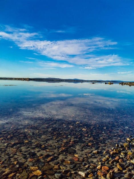 Побережье Белого моря в солнечный день с камнями в воде Карелии