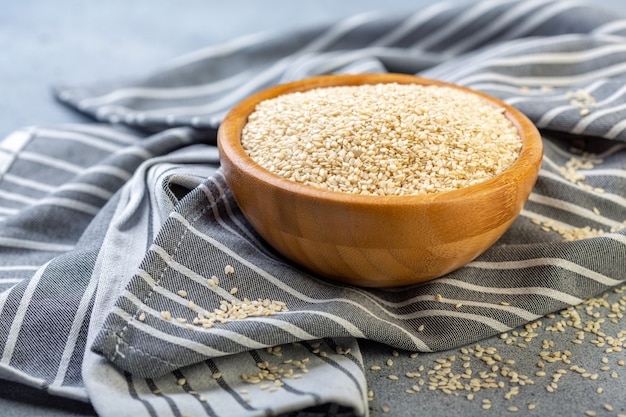 Photo white sesame seeds in a wooden bowl