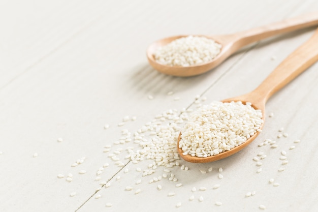 white sesame seeds on wooden spoon