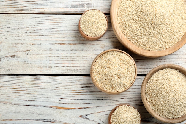 White sesame seeds on wooden table flat lay Space for text