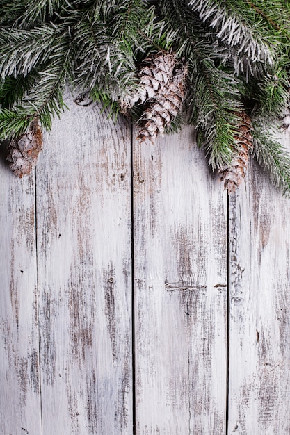 White shabby Christmas border with snow covered pinecones