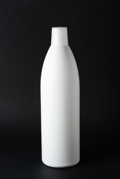 White shampoo bottle on black background