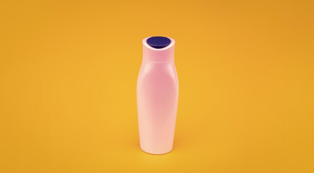 White shampoo bottle on yellow background beauty product