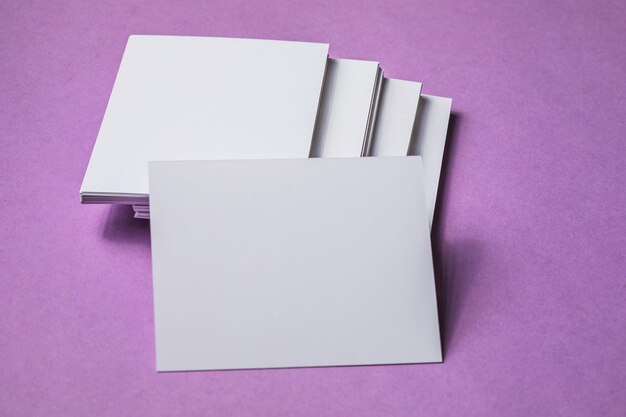 White sheet mockup Stack of blank name cards Blank white business card on purple paper background