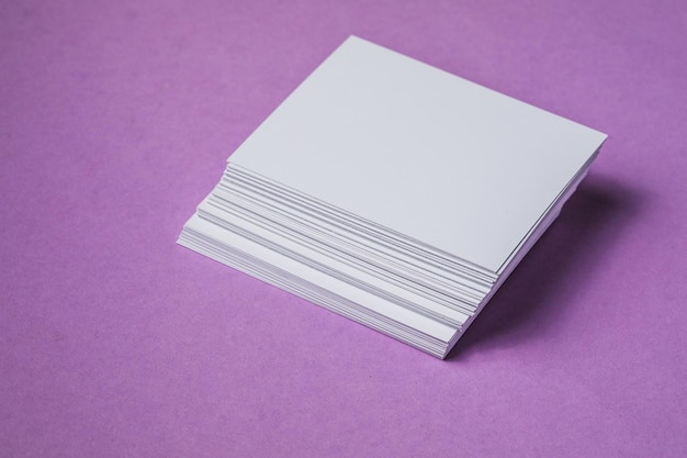 White sheet mockup Stack of blank name cards Blank white business card on purple paper background