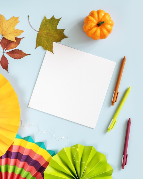 Foto foglio bianco di carta ventilatori di carta colorati penne e decorazioni su uno sfondo blu