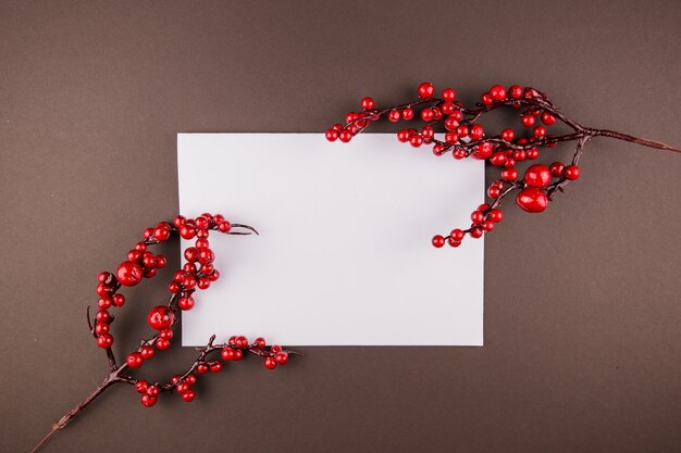 A white sheet of paper with a decor of red berries