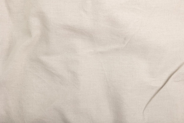 A white sheet with a gold ring on it is lying on a white cloth.