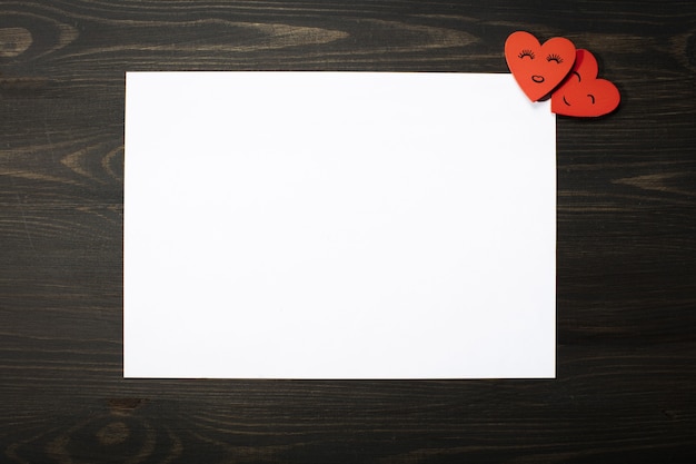 A white sheet with two red hearts on wooden.