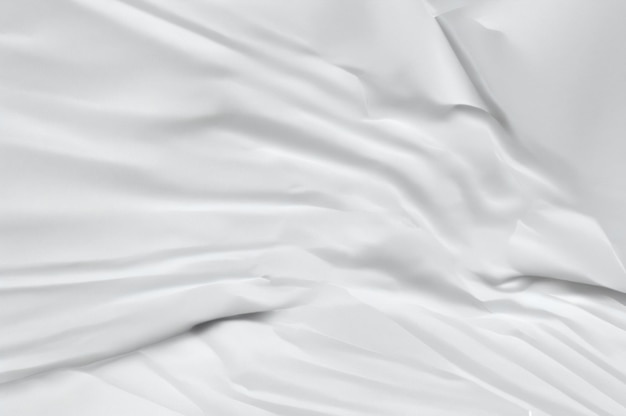 a white sheet with a very large folds on its side and a small white object in the middle of the she