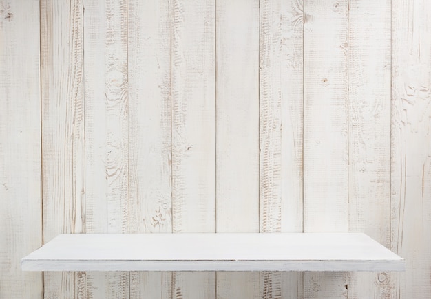 Photo white shelf on wooden wall texture