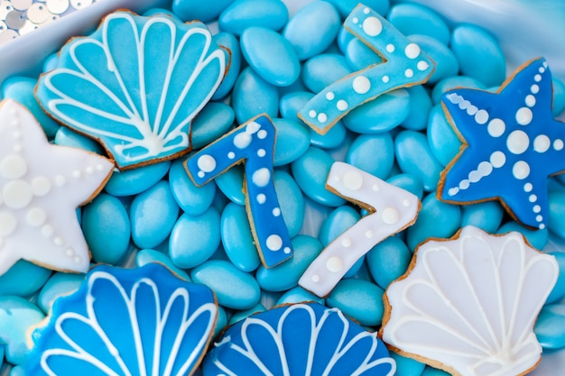사진 파란 입힌 초콜릿 사탕, 껍질, 별 및 숫자 7과 같은 쿠키로 가득 찬 흰색 껍질 판