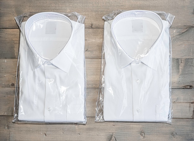 белая рубашка складывается на белом деревянном фоне