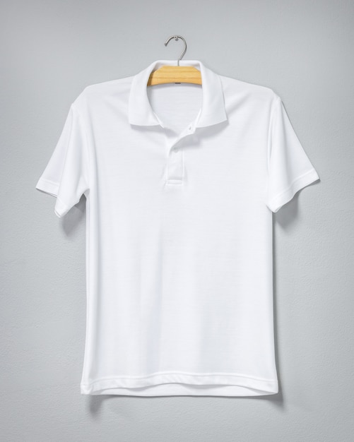 White shirt hanging on cement wall. Blank t-shirt for printing. Front view.