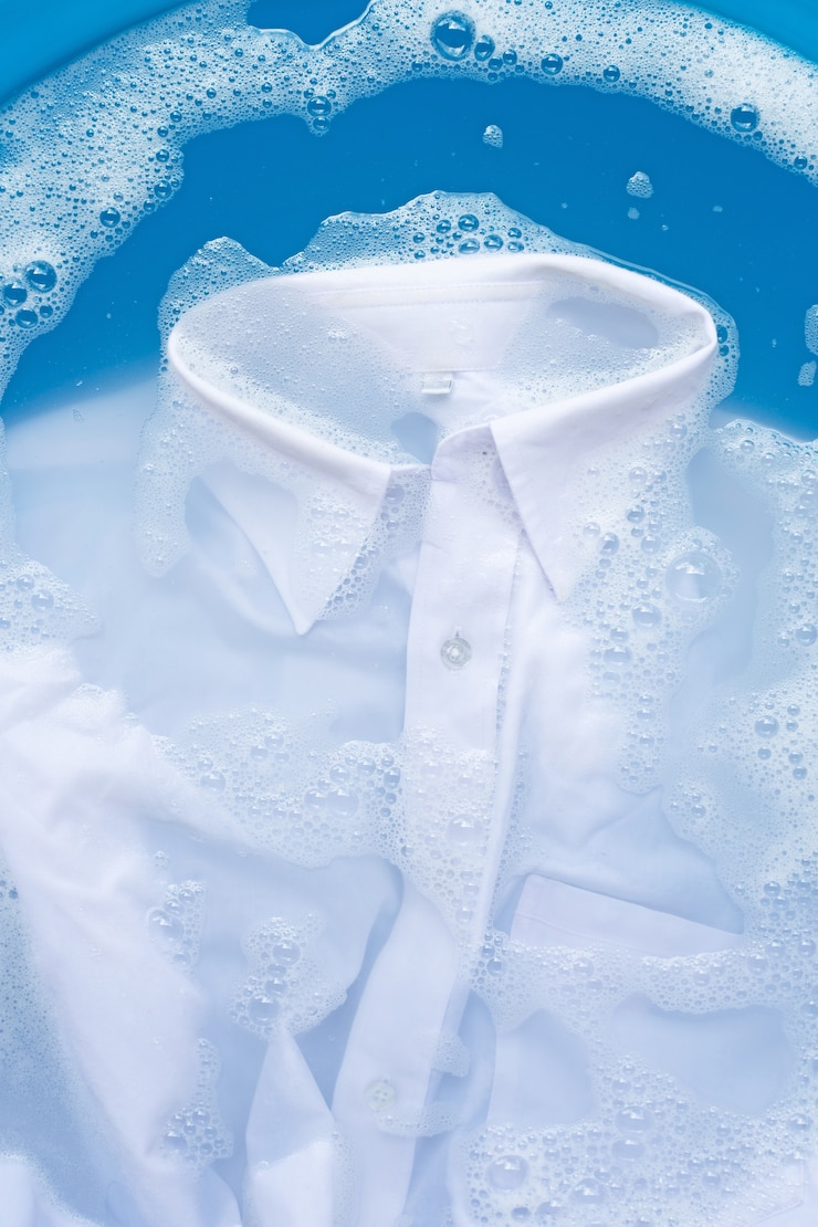 Photo white shirt soak in powder detergent water dissolution. laundry concept