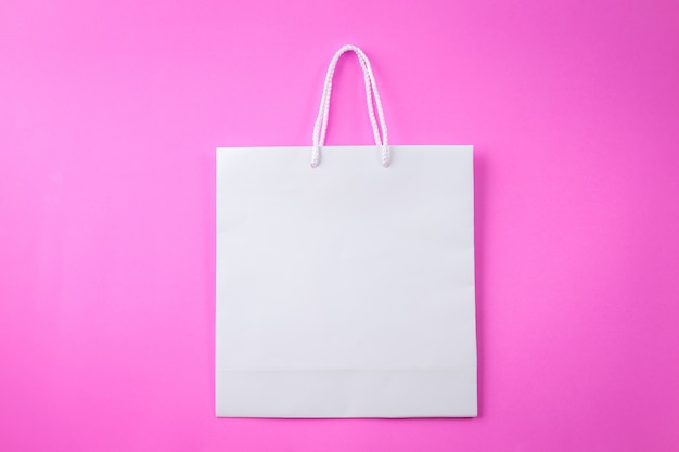 Shopping bag bianco uno sfondo rosa e copia spazio per testo normale o prodotto