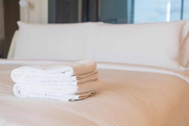 white shower towel stack on bed