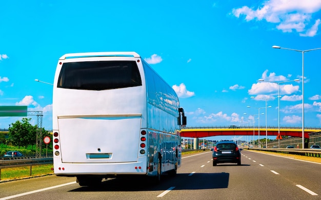 White shuttle bus back in road, poland. modern public transport traffic and summer drive. charter coach vehicle on vacation trip. holiday journey for recreation. motion and urban ride