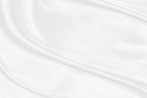 White silk textured cloth backgroundCloseup of rippled satin fabric with soft waves
