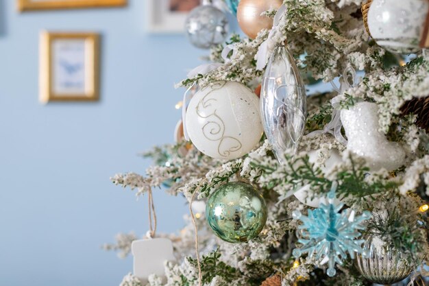 white and silver toys Festively decorated Christmas tree with garlands Symbol of the new year.