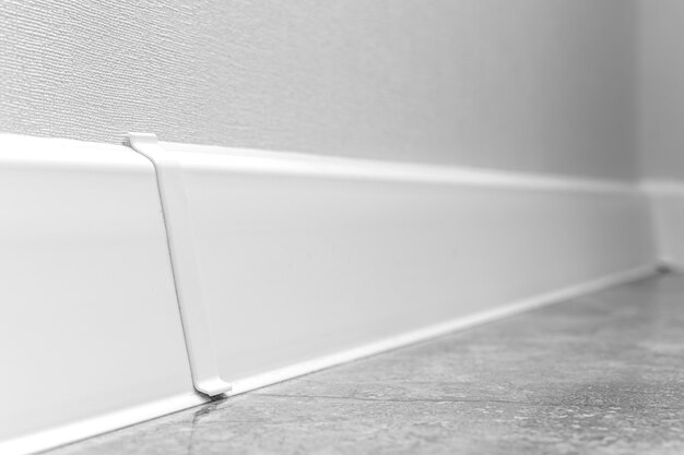 White skirting boards close-up, modern apartment interior design background wit selective focus composition photo