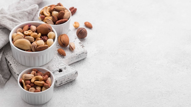 Photo white small bowls filled with assortment of nuts copy space