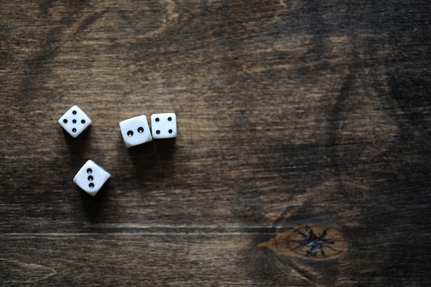 Photo white small dices on a brown wooden texture table